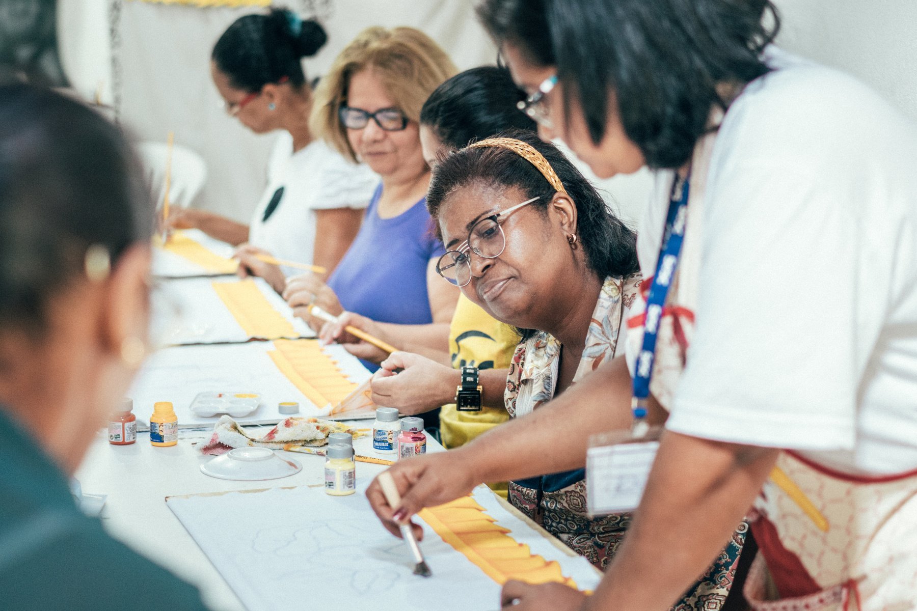 group of brazilian women painting textiles in work room of social project