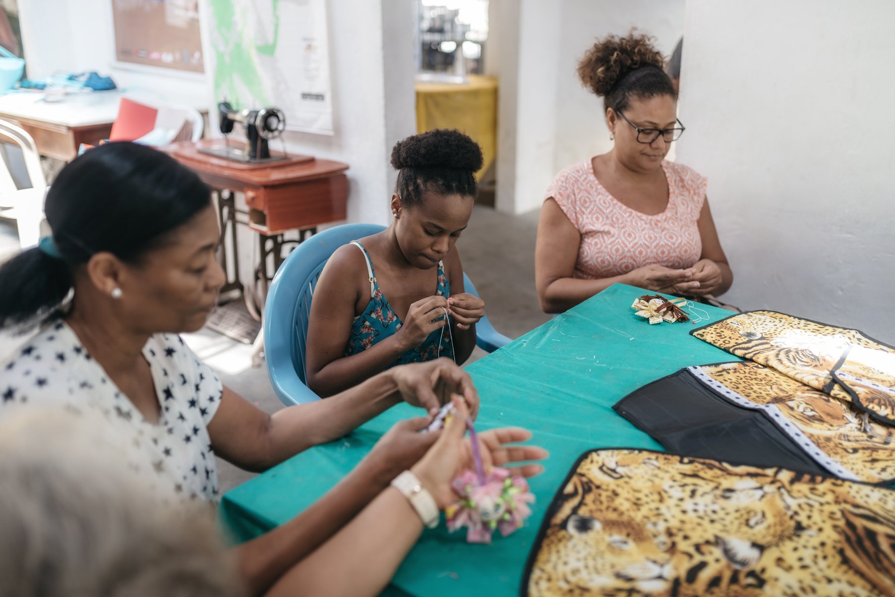 four brazilian woman sewing in tailor work room of social project